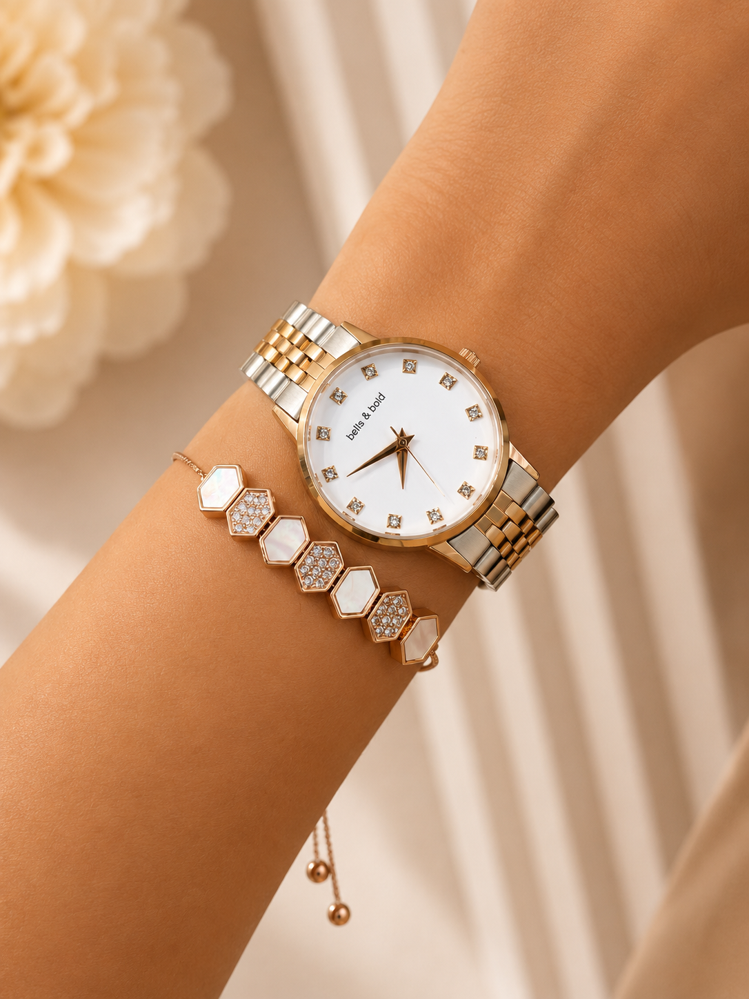 Gold and silver watch on a wrist with a soft background